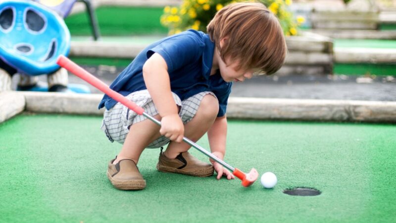 A child playing mini golf in Sarasota with the family